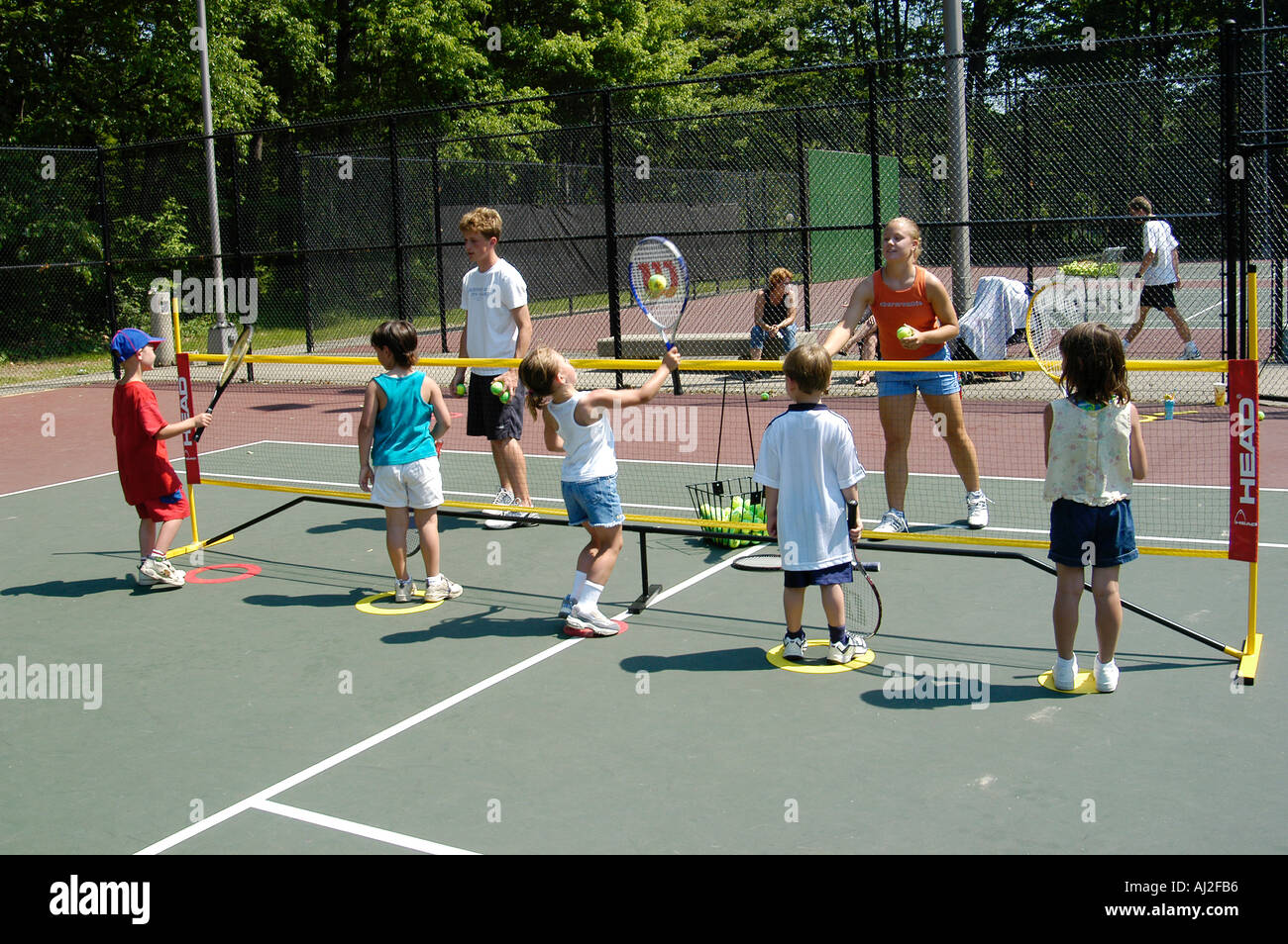 I ragazzi imparano a giocare a tennis presso il pubblico corte di ricreazione Foto Stock