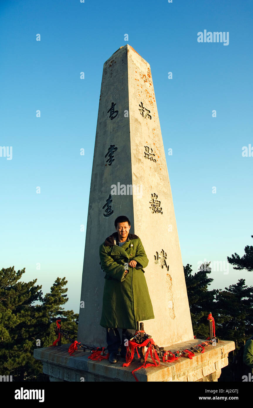 Un uomo in verde esercito camicia su un monumento sulla cima del monte Hua, un picco di granito mountain (2160m) nella provincia di Shaanxi Foto Stock