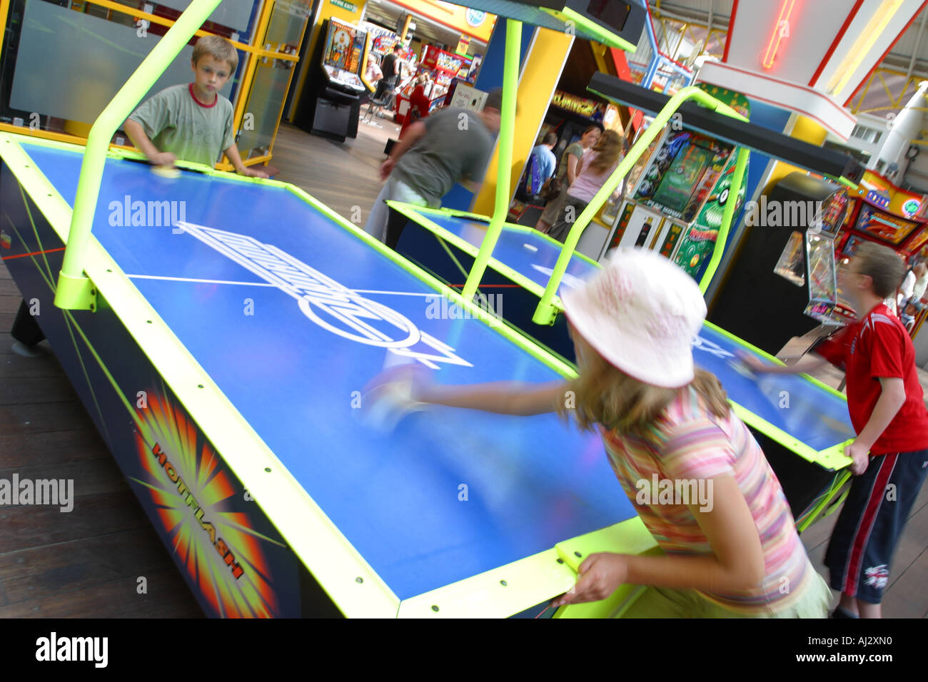 Bambini che giocano air hockey gioco all'interno di seaside amusements fiera arcade Foto Stock