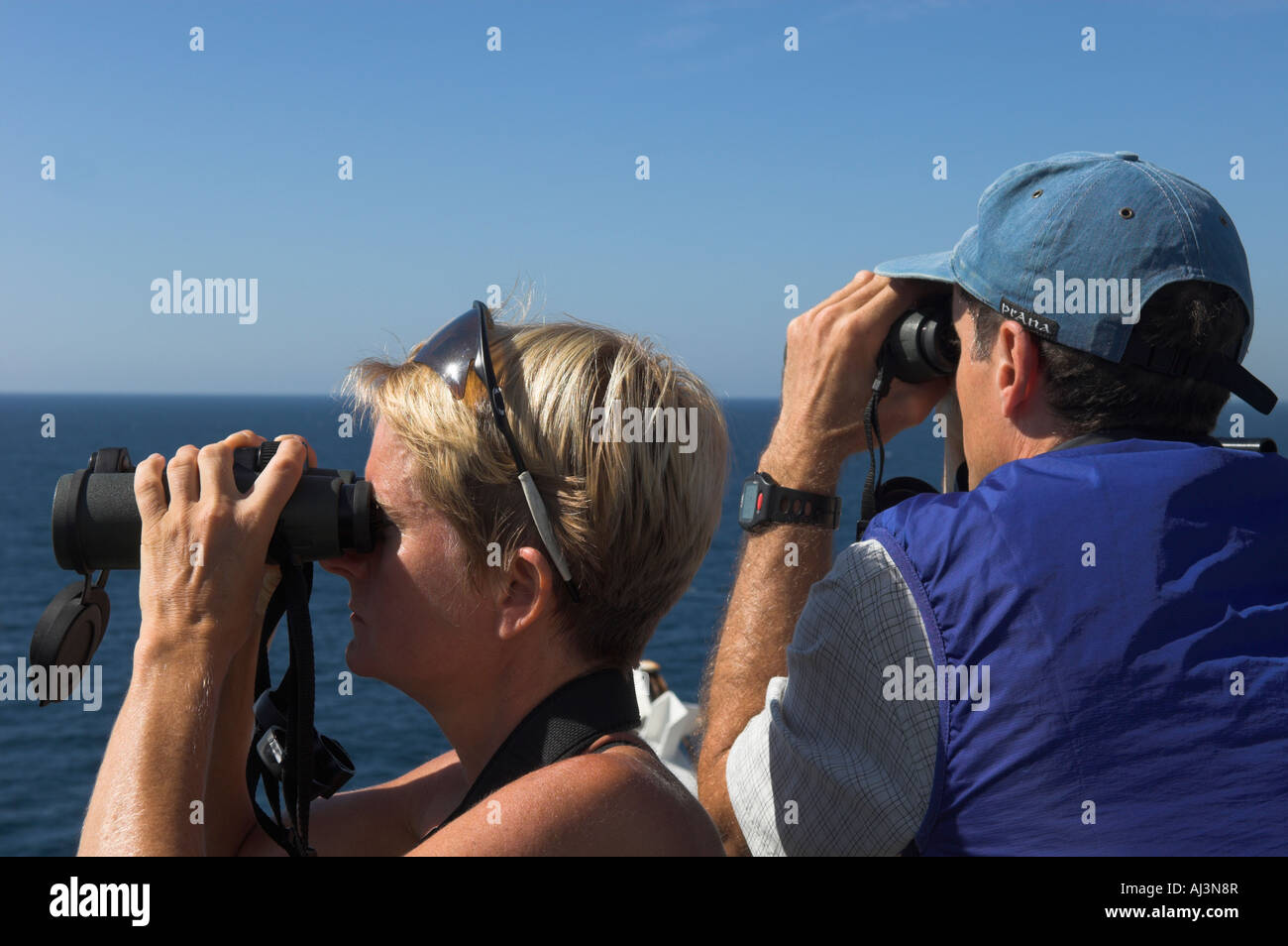 Primo piano di un uomo e di una donna a guardare il mare con il binocolo Foto Stock