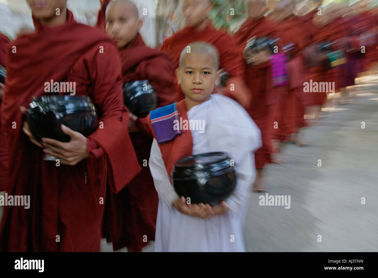 Monaci in attesa in linea per elemosina, Maha Gandayone Monastero, Mandalay Myanmar Foto Stock