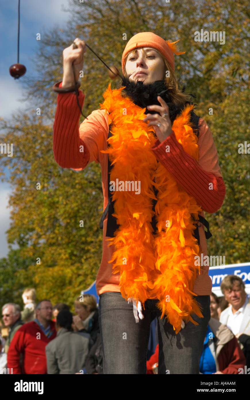 Brillantemente vestito Lady playing conkers Foto Stock