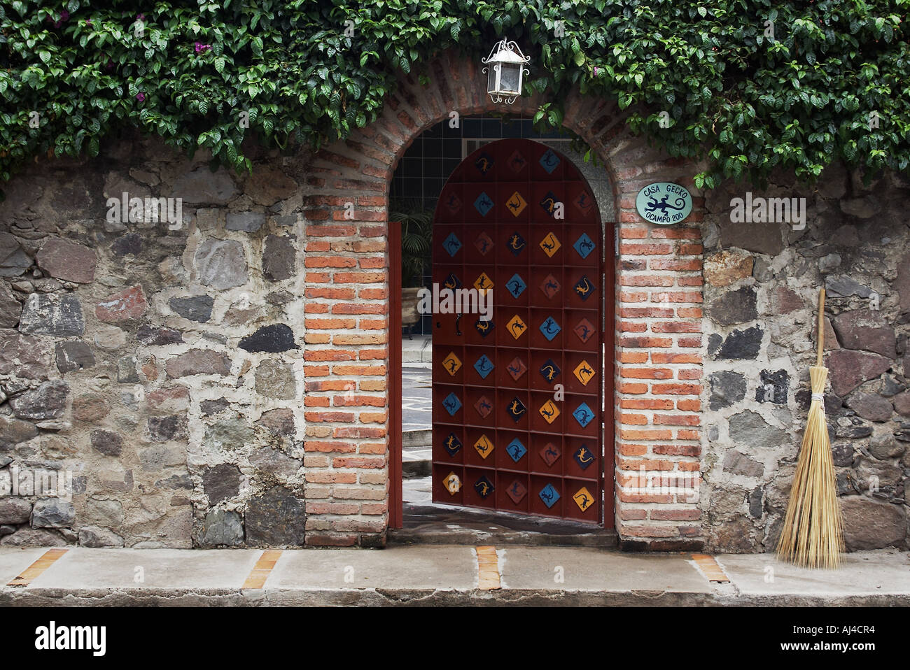 Casa Gecko-The leggermente socchiusa e porta di ingresso in una casa murata in Ajijic Messico Foto Stock