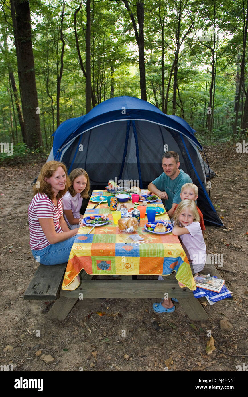 Camping famiglia mangiare al tavolo da picnic con la tenda in background  O'Bannon boschi del Parco Statale Indiana Foto stock - Alamy