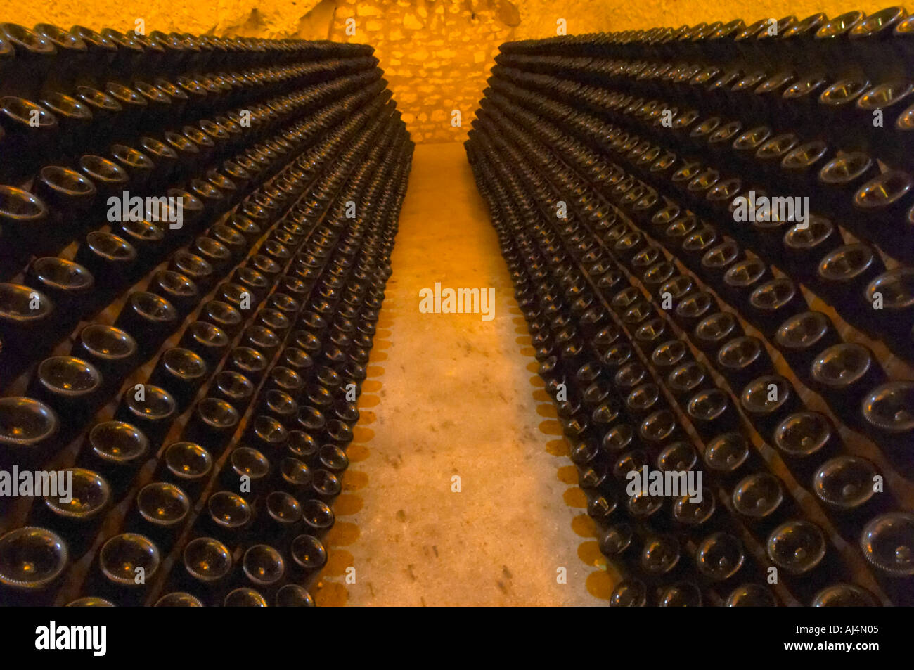 Nella cantina sotterranea che è una vecchia cava di gesso: migliaia e milioni di bottiglie di invecchiamento, questi sono in piedi in rack (pupitres) in attesa di sboccatura, Champagne Ruinart, Reims, Champagne, Marne, Ardenne, Francia, bassa luce grano sgranate Foto Stock