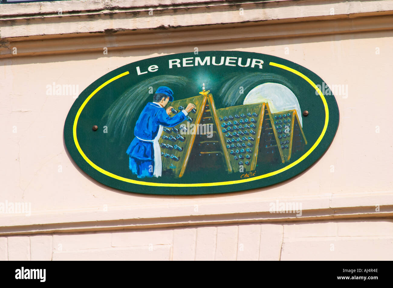Un segno dipinto che illustra il tema della champagne e la produzione di vino: Le Remueur - the riddler delle bottiglie in una cantina a volta con pupitres, il villaggio di Hautvillers nella Vallée de la Marne, Champagne, Marne, Ardenne, Francia Foto Stock