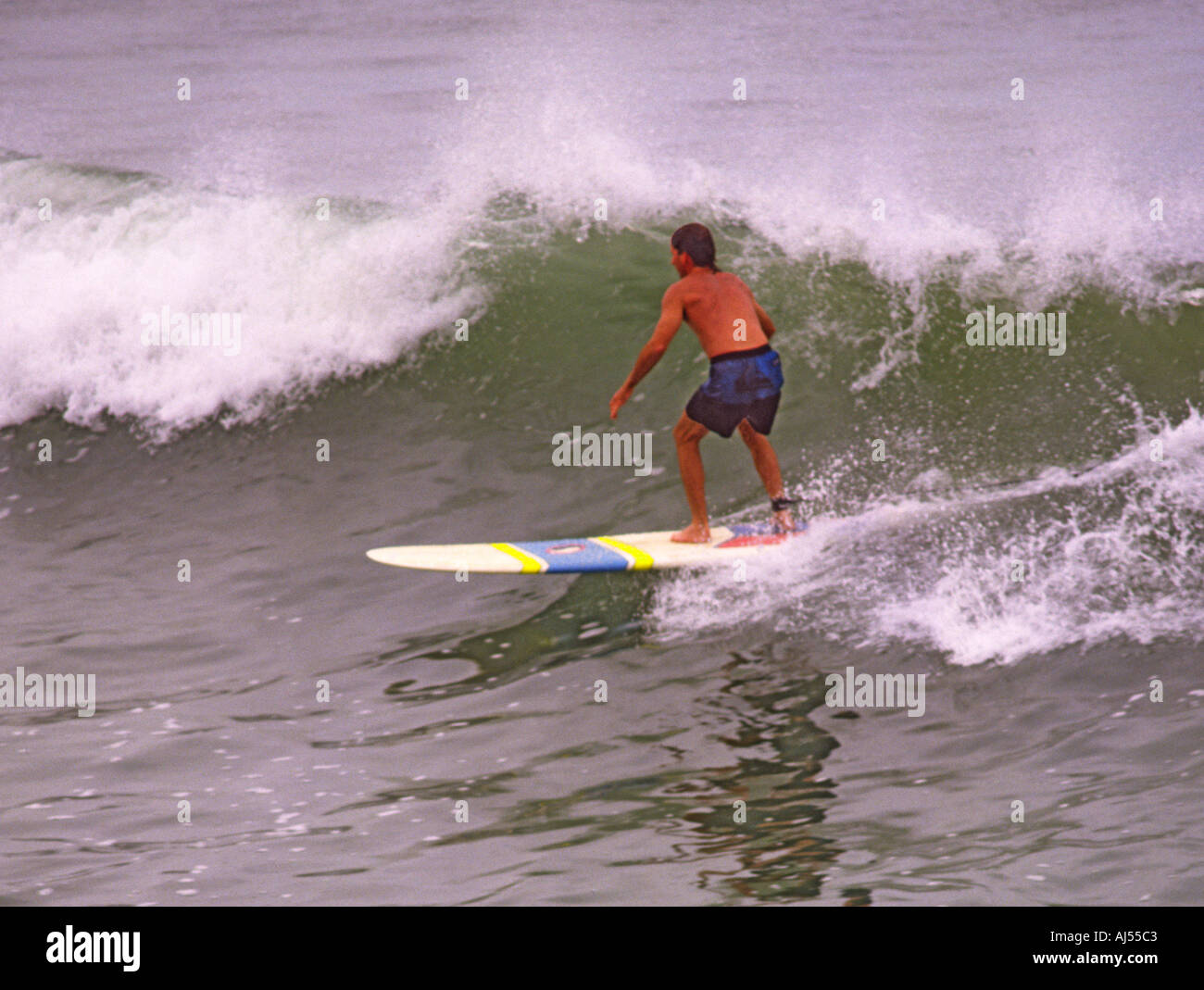 Unico longboard surfer godendo di una corsa su una piccola onda di rottura a North Beach Durban Natal provincia Sud Africa Foto Stock