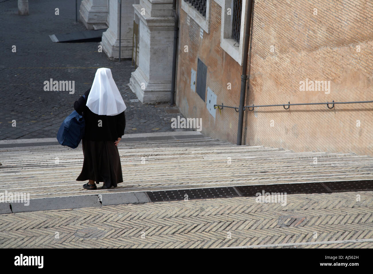 Una suora in piena abitudine a camminare verso il basso dei gradini ripidi Roma Lazio Italia Foto Stock