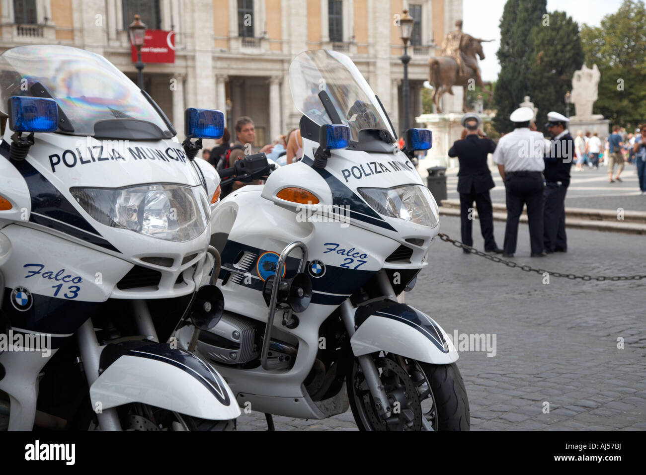 La polizia municipale di stand in chat con lo sfondo dietro due moto della polizia in Campidoglio a Roma Lazio Italia Foto Stock