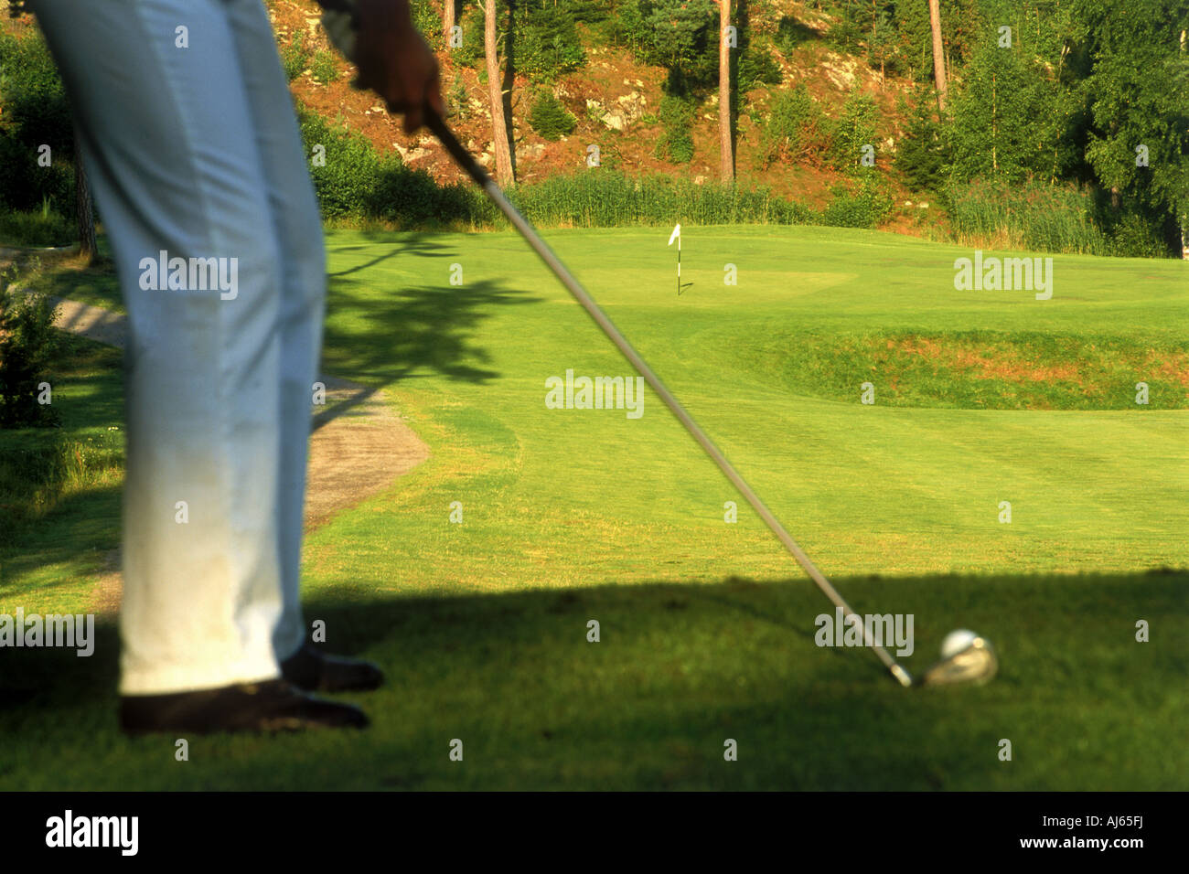 Il Golfer colpendo con ferro spento lussureggianti fairway Foto Stock