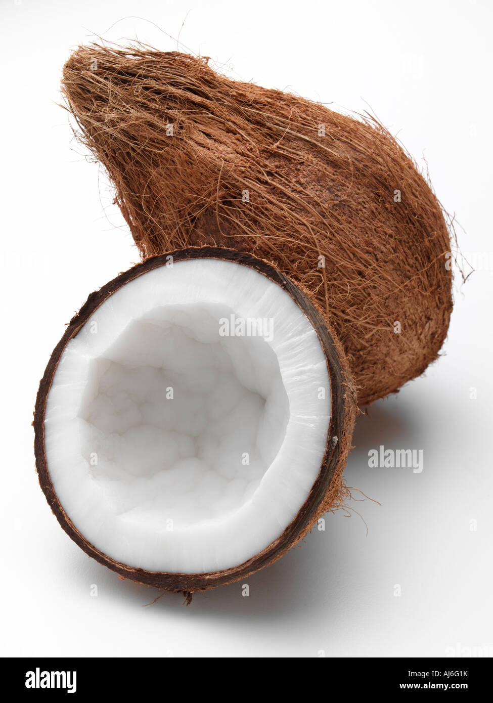 Una intera e una mezza noce di cocco su sfondo bianco Foto Stock