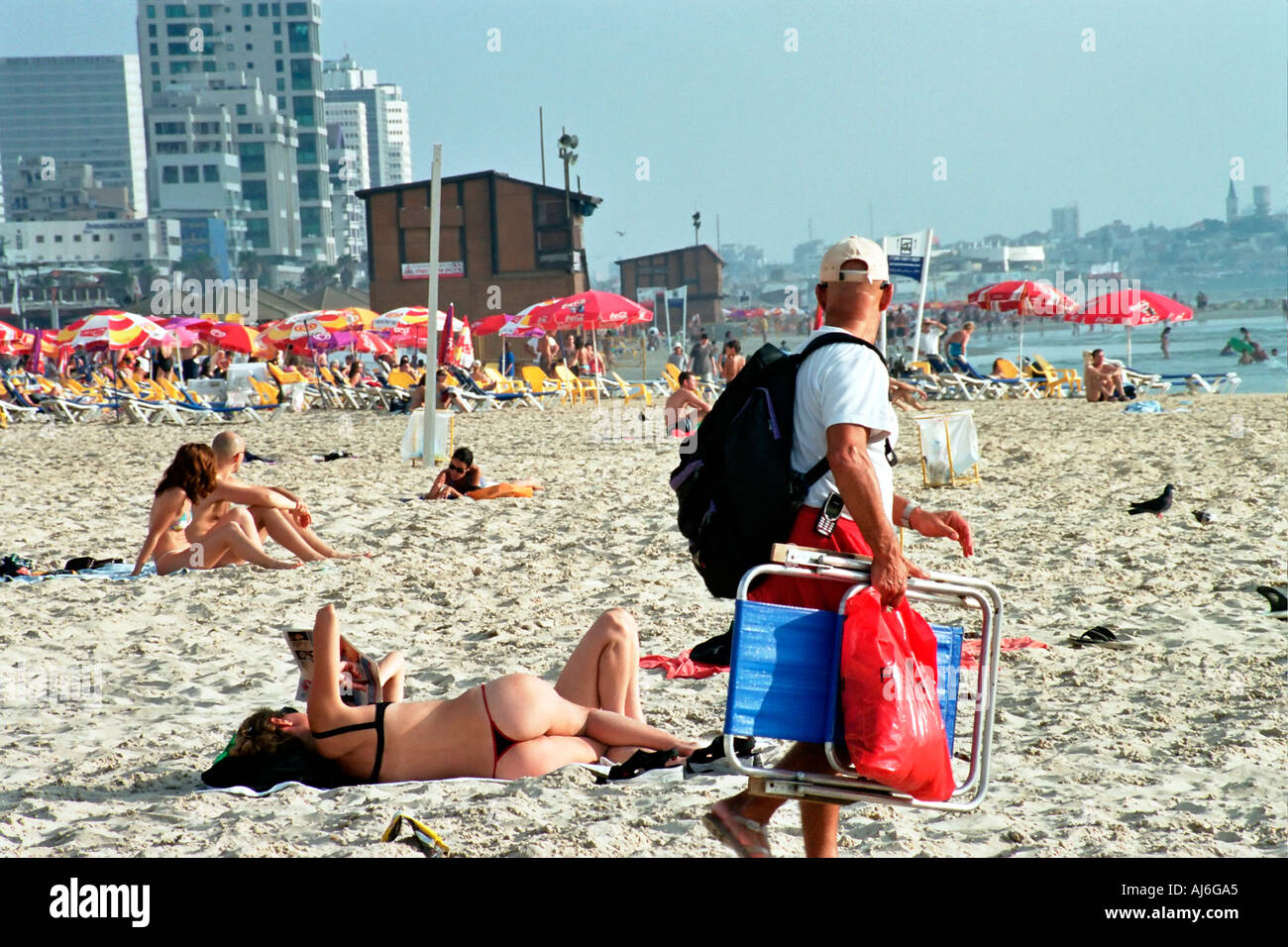 Israele Tel Aviv uomo fissando una donna per i bagni di sole con un laccetto Foto Stock