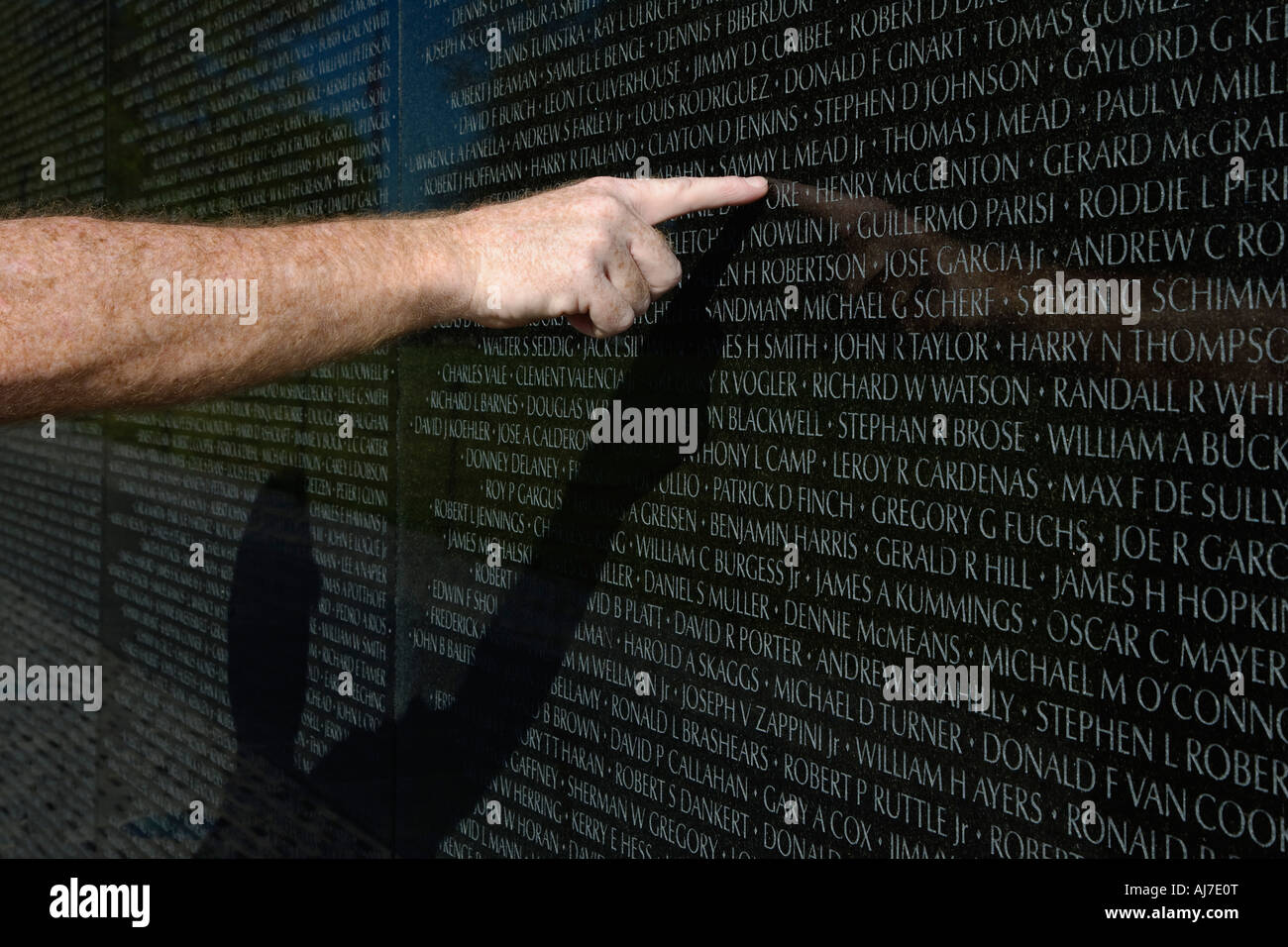 Il Veterano dell'esercito punti per il nome di un compagno sulla parete del Vietnam Veterans Memorial di Washington DC. Foto Stock