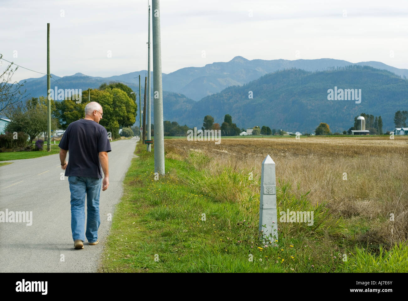 Uomo che cammina passato Canada US monumento di confine numero 32 sulla 49th parallelo Abbotsford della Columbia britannica in Canada Foto Stock