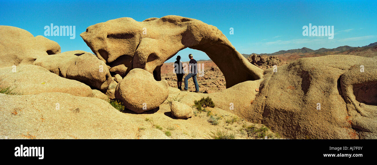 I turisti nei pressi di arco in pietra. La parte meridionale del bacino di Nemegt (Valle dei draghi, fossili di dinosauro). Deserto dei Gobi. Mongolia Foto Stock