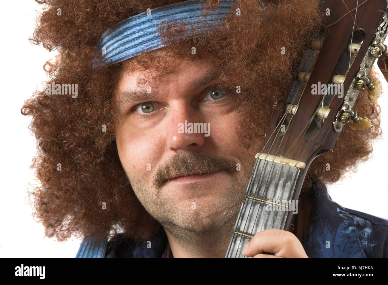 Hippie con un pazzo leggermente occhiata tenendo la sua chitarra testo sulla maglietta non è un brandname Foto Stock