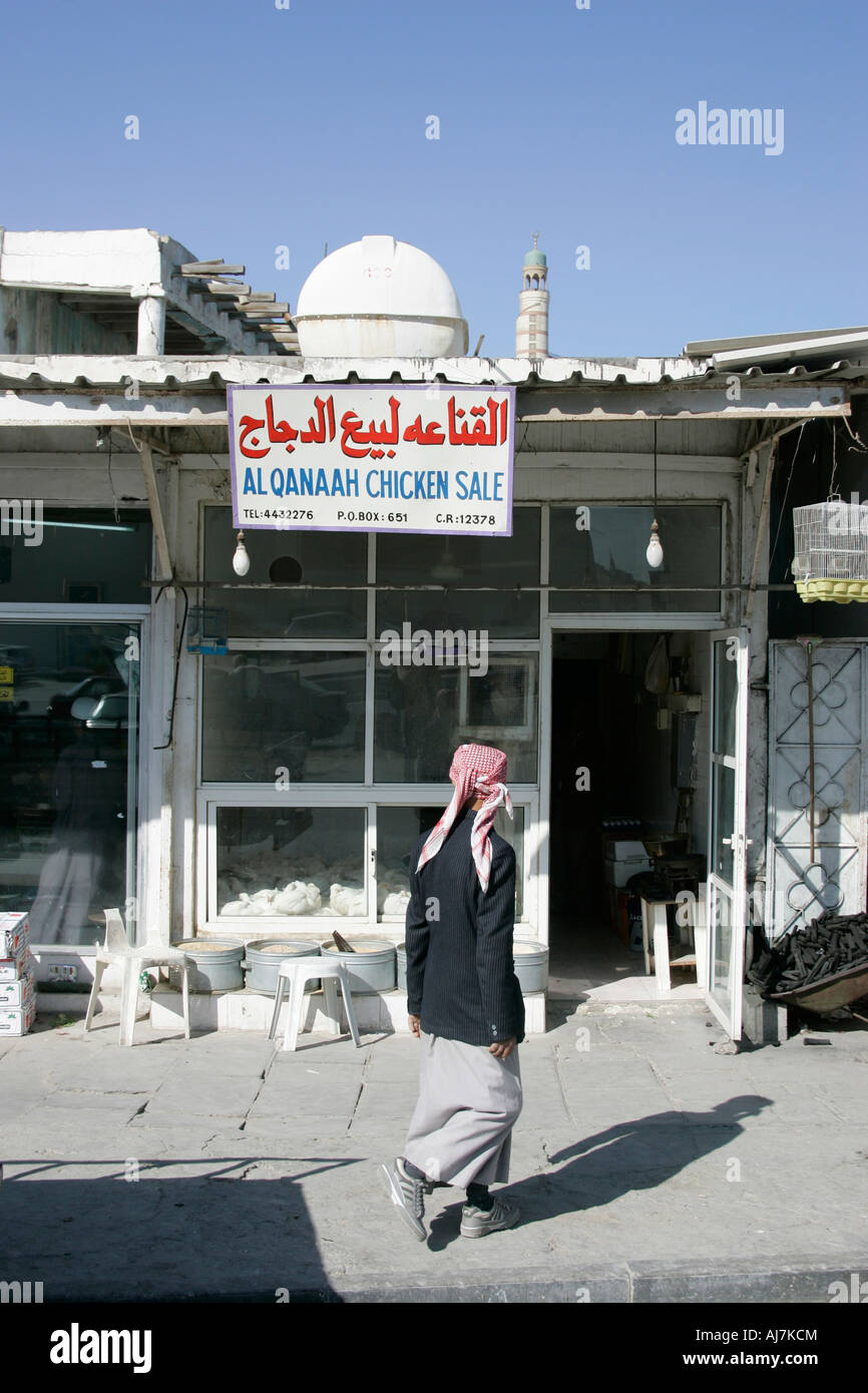Uomo arabo entrando in negozio di vendita di polli vivi a Doha, Qatar, Foto Stock