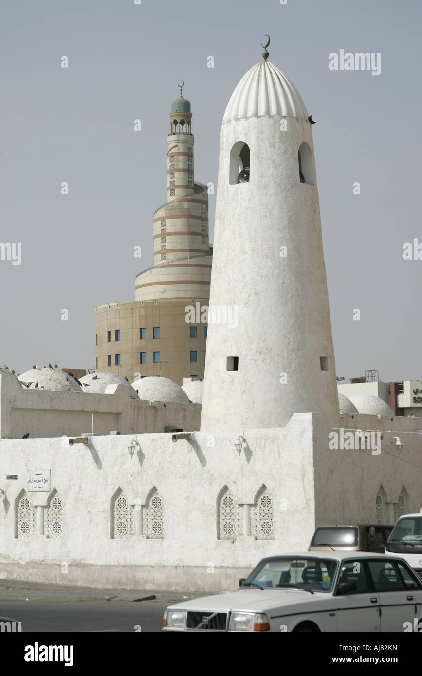 Vecchio tradizionale Qassim moschea e la nuova moderna moschea Qatar in background Foto Stock
