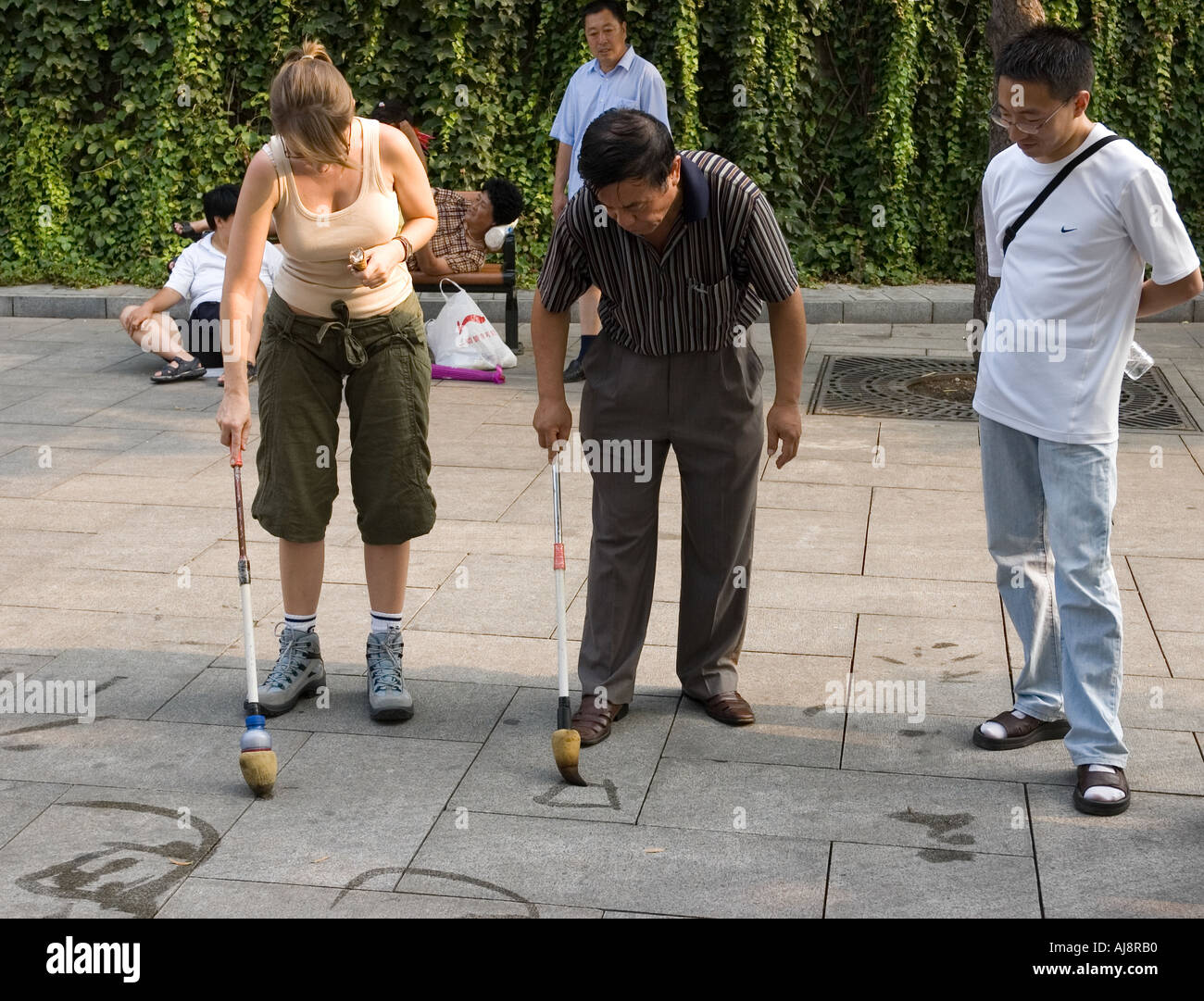 L'uomo insegnare la calligrafia cinese con acqua pennello sul marciapiede in Parco Beihai Pechino, Cina Foto Stock