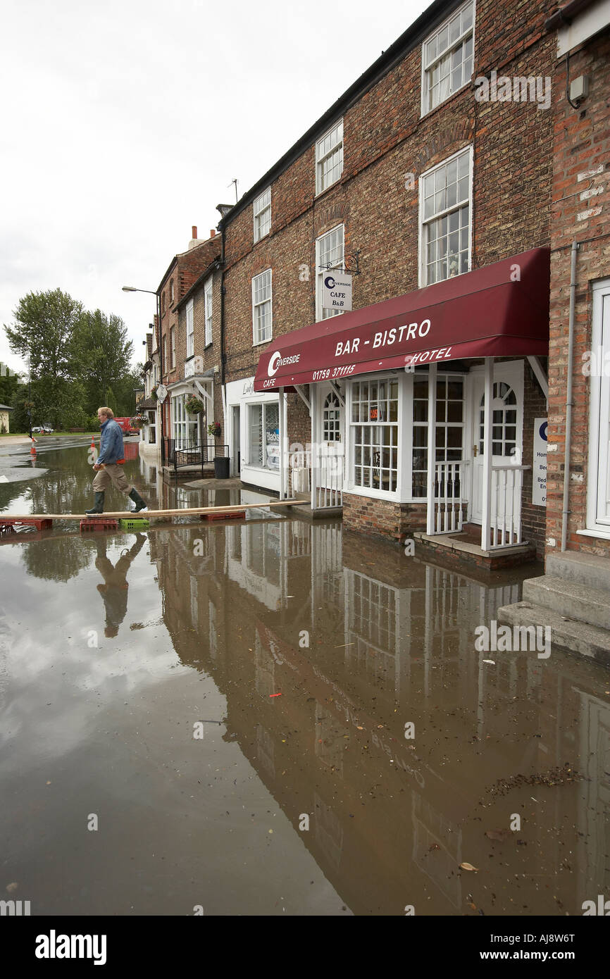 Shopper camminando sulla piattaforma su acqua di inondazione per raggiungere negozi di Stamford Bridge East Yorkshire Regno Unito Giugno 2007 Foto Stock