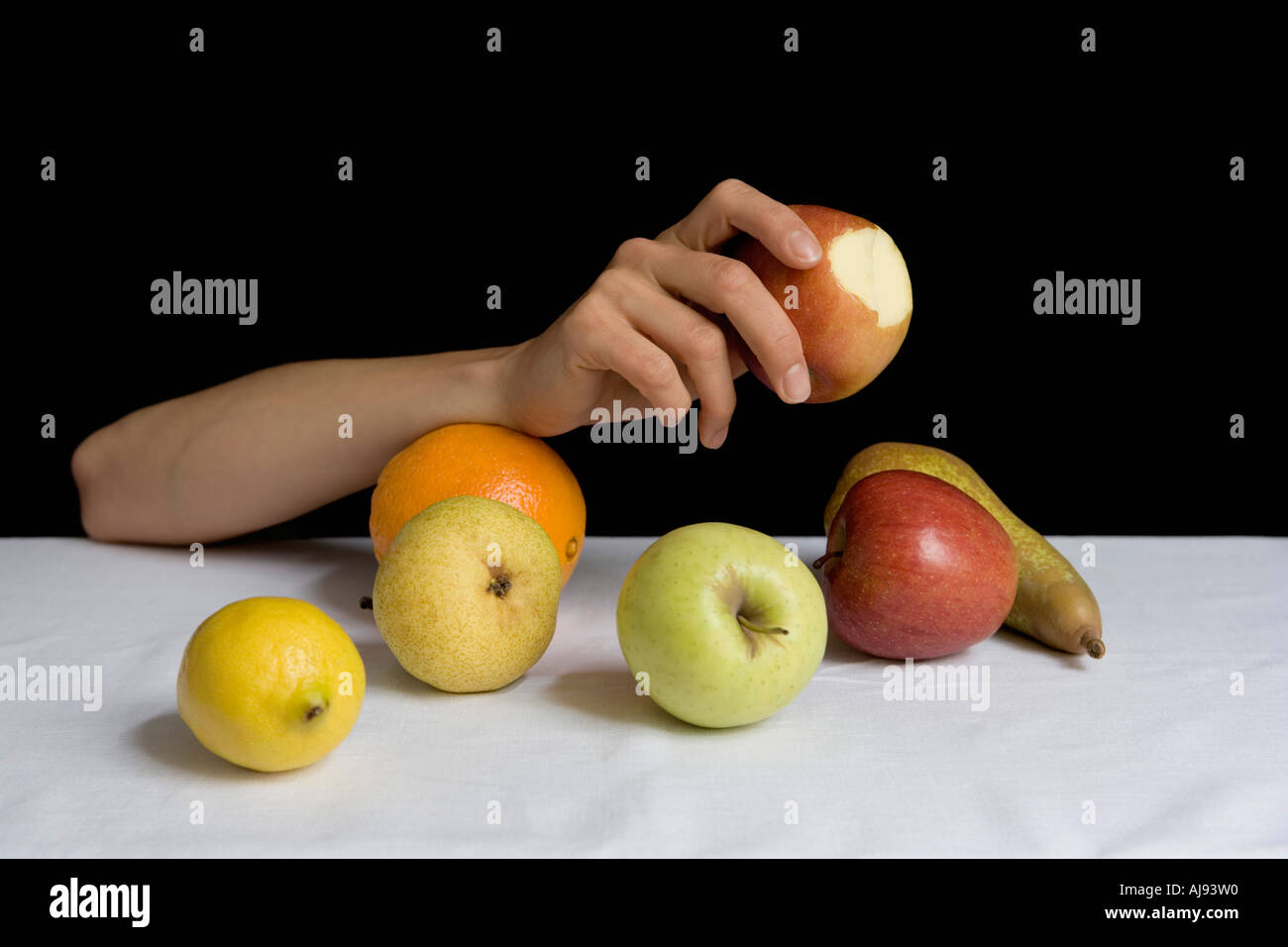 Braccio appoggiato sulla tavola tra la frutta Foto Stock