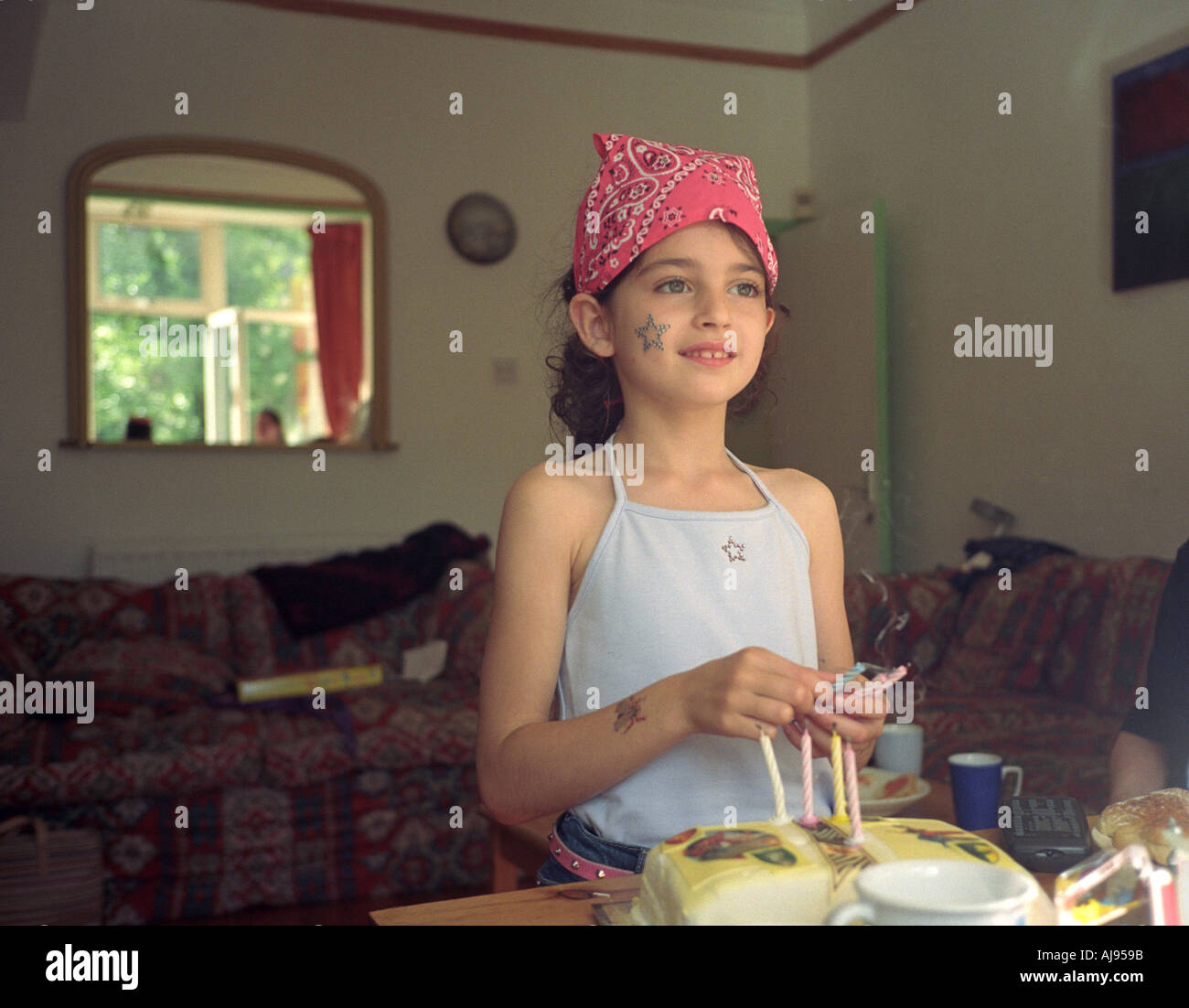 Una ragazza festeggia il suo sesto compleanno tenendo le candele che ha bruciato. Foto Stock