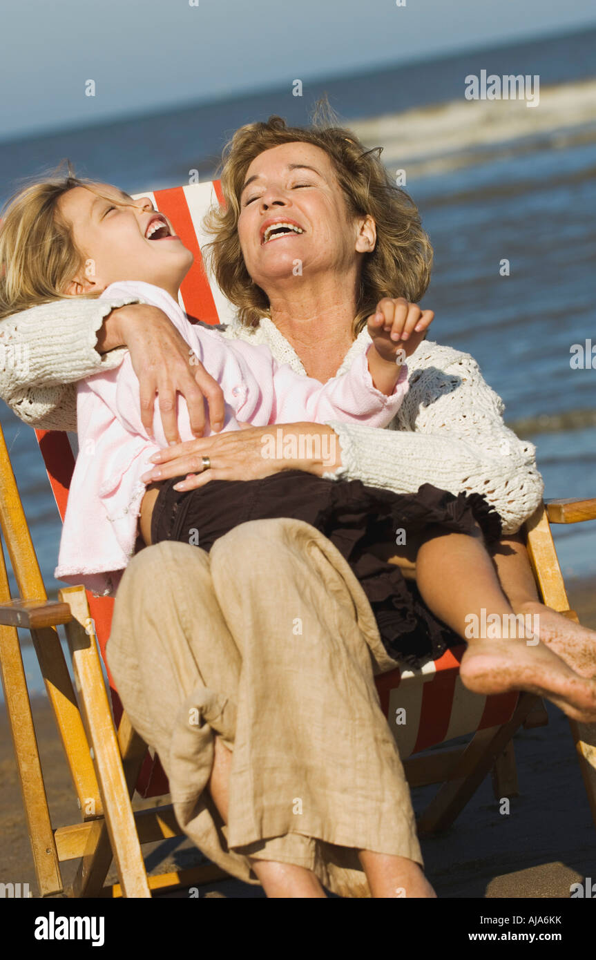 Nonna divertendosi con la nipote in sedia spiaggia Foto Stock