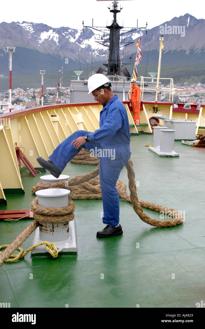 Sailor rendendo veloce linee di ormeggio come di un icebreaker docks a fianco della banchina in Ushuaia Argentina Foto Stock