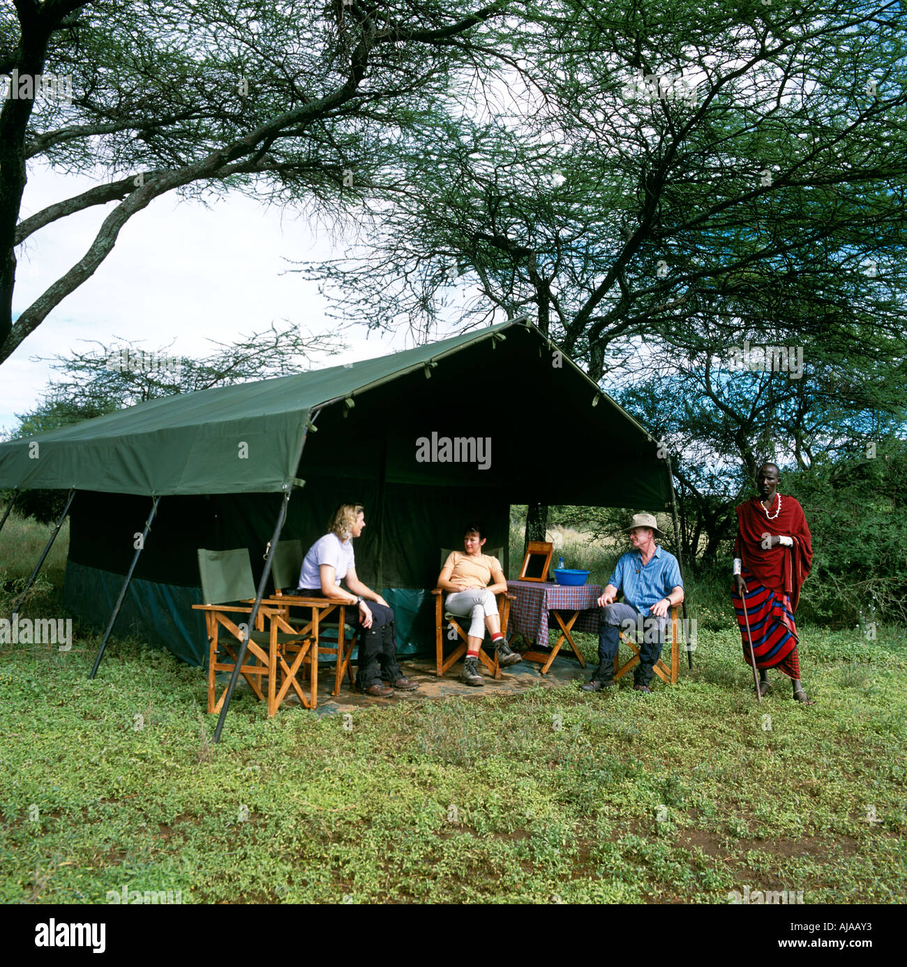 Safari Camp turisti e Masai Warrier Tanzania Africa orientale Foto Stock