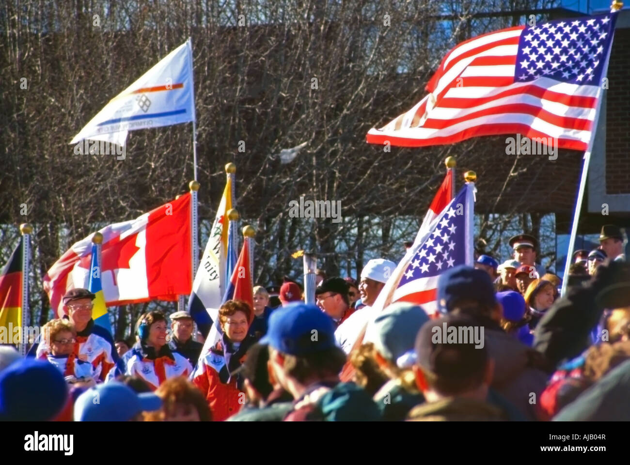 Una patriottica, bandiera sventola colpo di varietà di gente che è venuto fuori in inverno freddo per vedere la torcia olimpica passano in Utah, Stati Uniti d'America Foto Stock