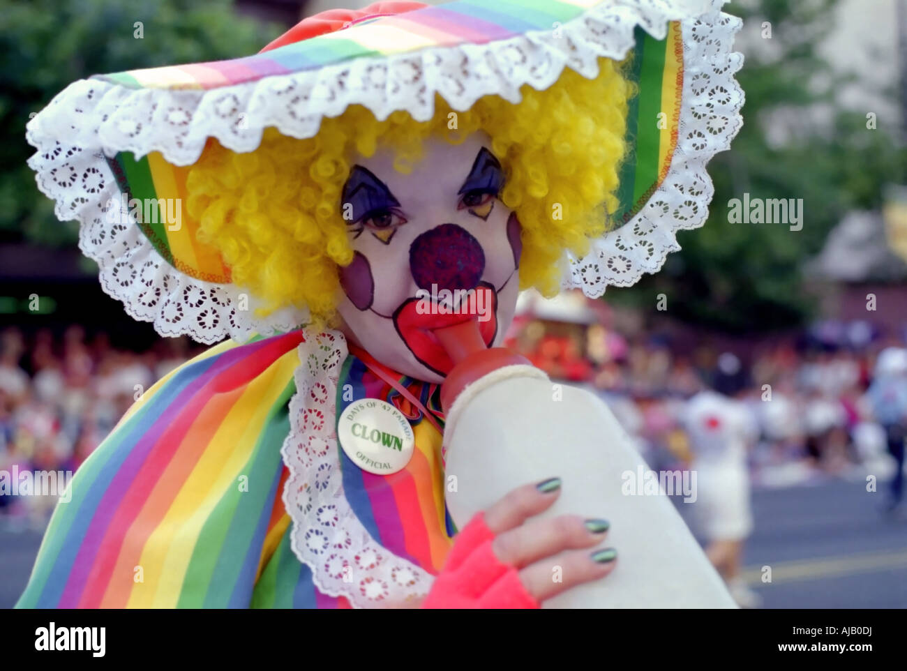 Un modo divertente di close-up verticale di un incolto 'baby' clown w/ la sua bottiglia. Lei è stato uno dei molti clown animatori presso la parata. Foto Stock
