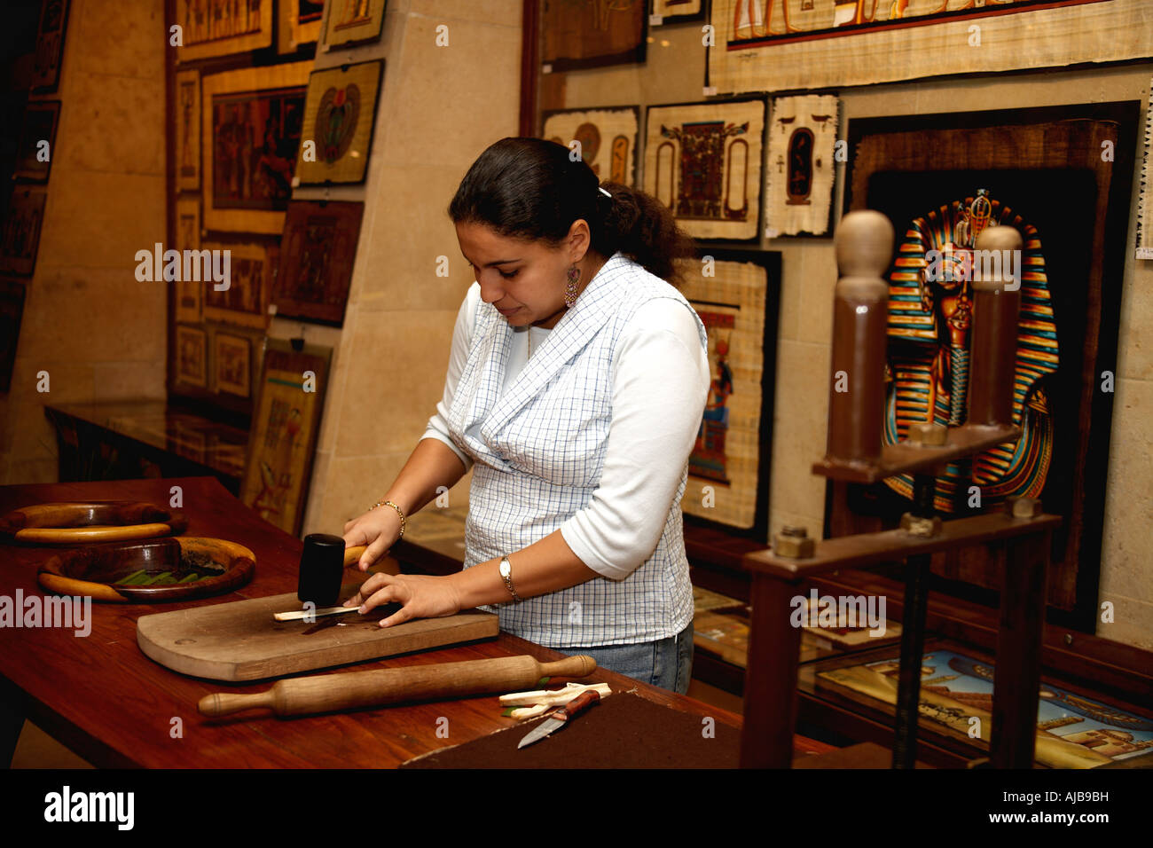 Donna dando dimostrazione di un processo di fabbricazione di carta papiro in galleria d'arte Il Cairo Egitto Africa stadio due appiattimento ste Foto Stock