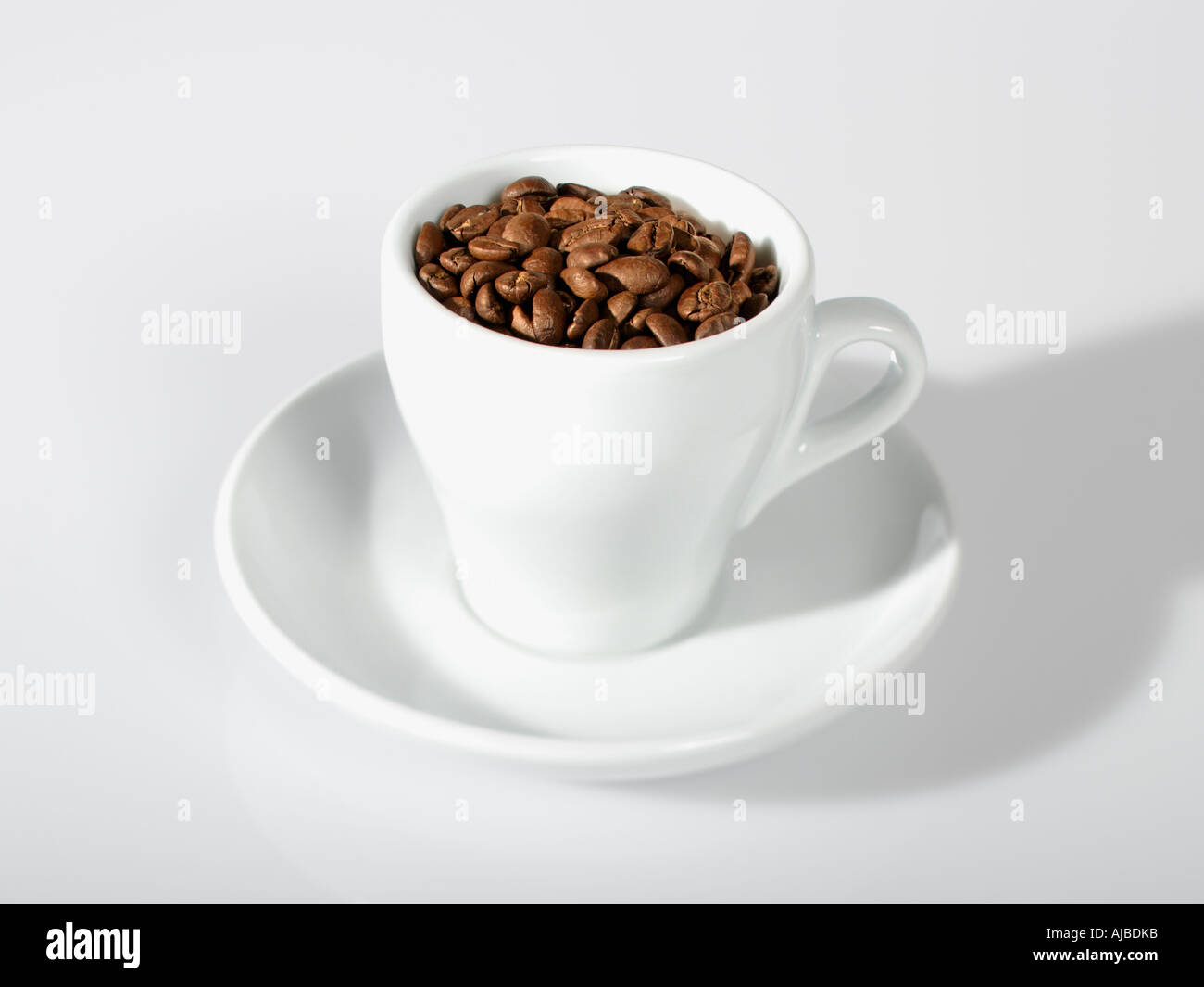 Chicchi di caffè tostati in tazza bianca Foto Stock