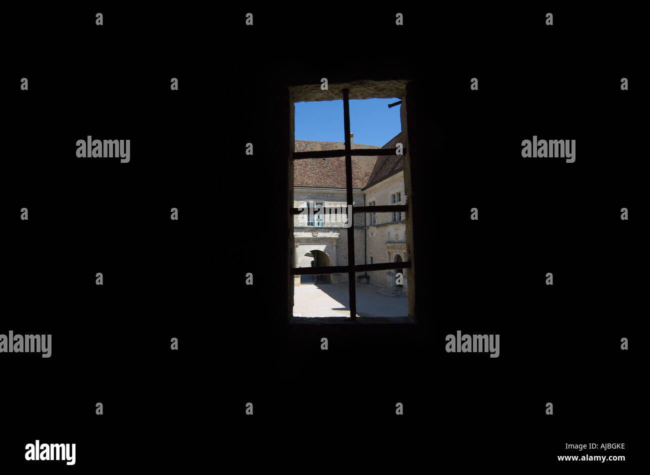Vista attraverso una finestra medievale da un interno nero Foto Stock