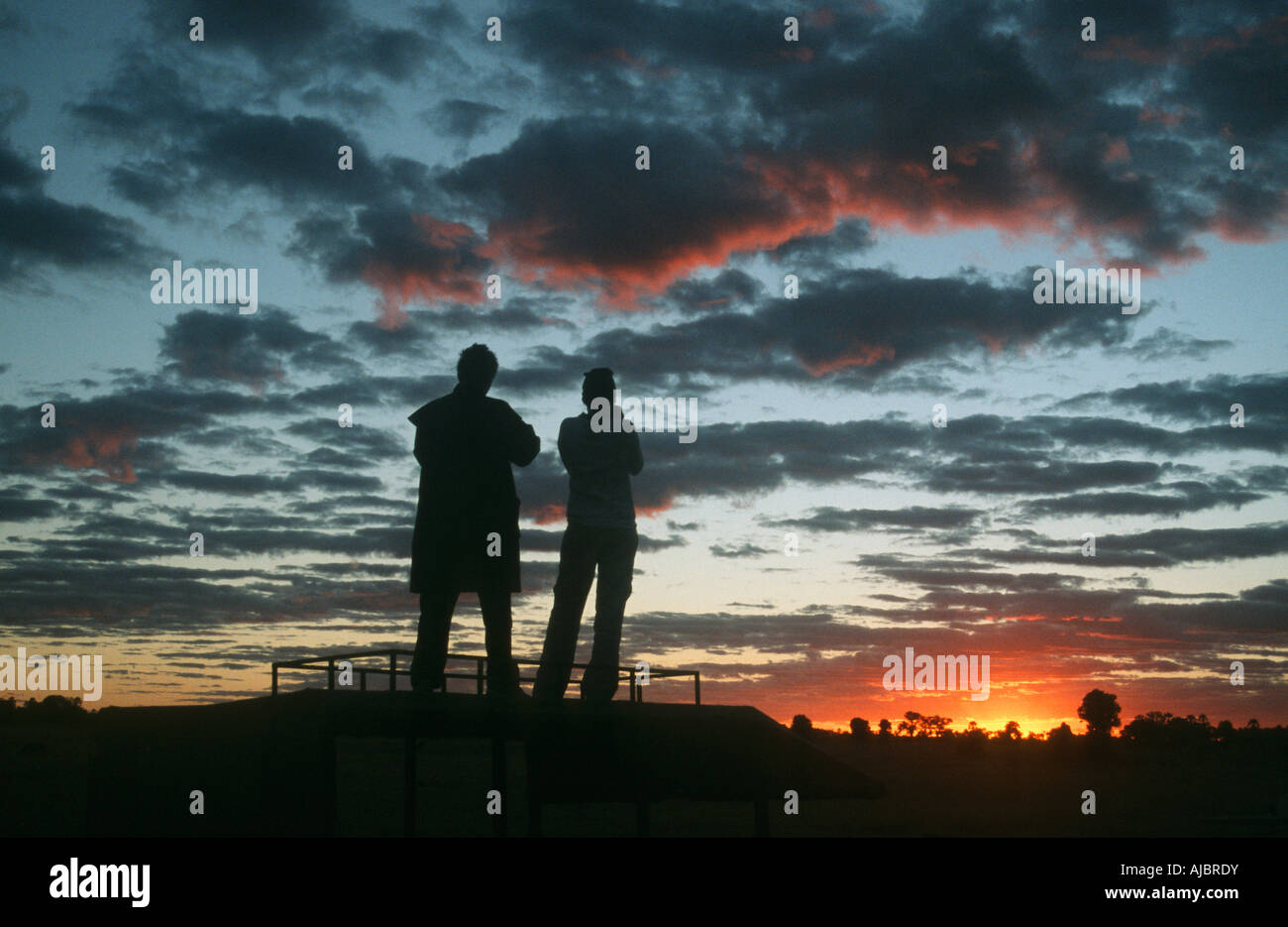 Silhouette di una giovane ammirando il tramonto Foto Stock