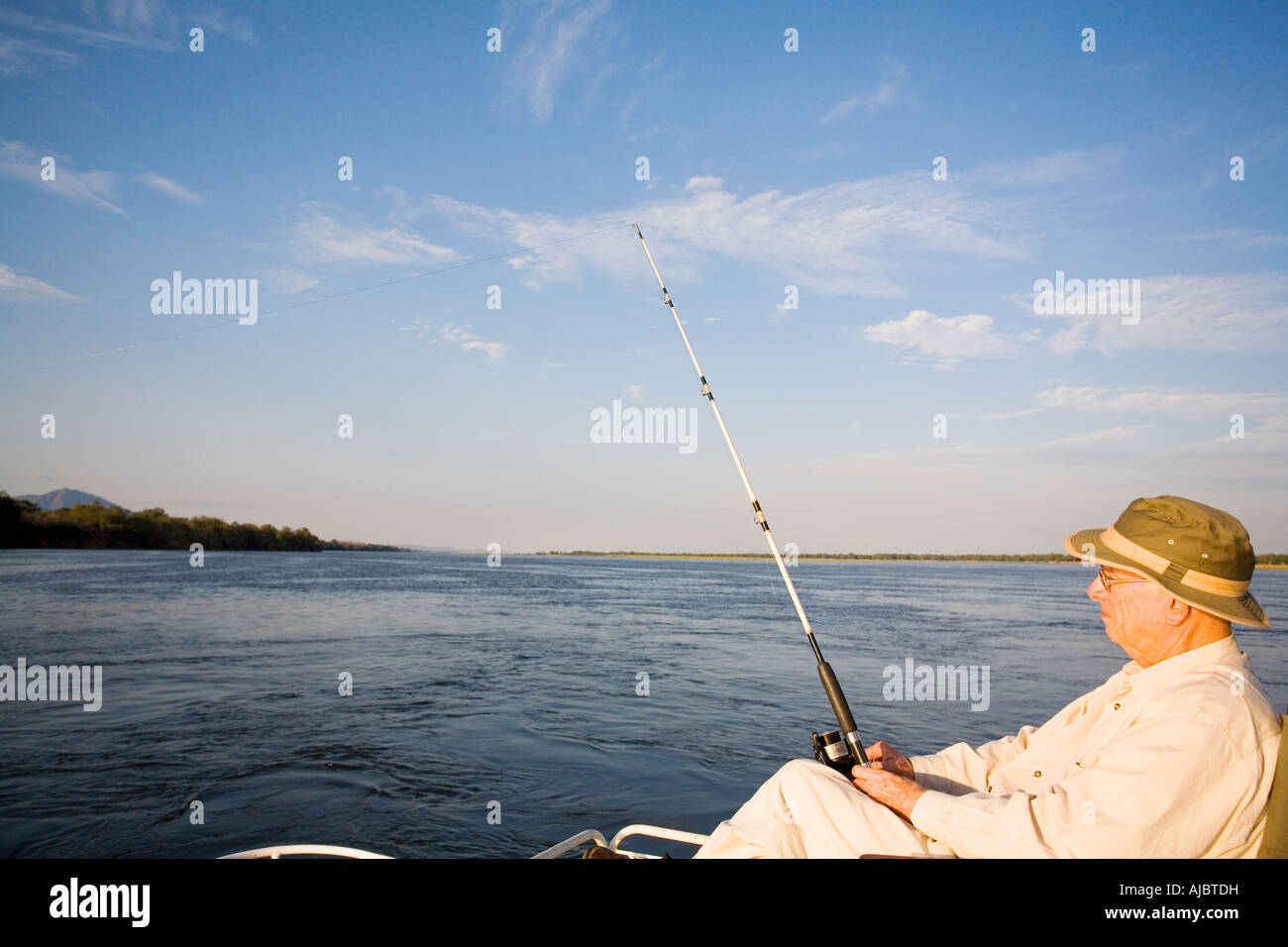 Uomo maturo la pesca nel fiume Zambesi Foto Stock