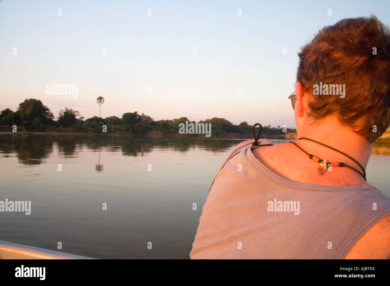 Giovane uomo su una barca - Visualizzazione del Fiume Luangwa al tramonto Foto Stock