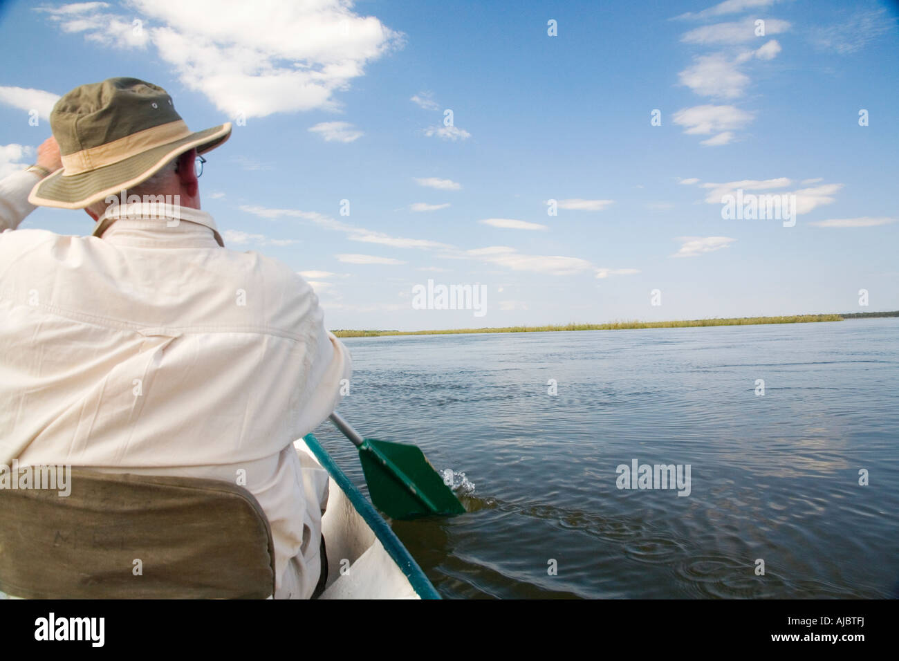 Uomo maturo canottaggio in canoa sul fiume Zambesi - Vista posteriore Foto Stock