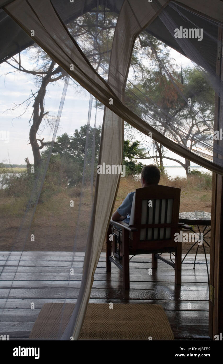 Giovane uomo sul portico ammirerete la vista sul fiume Zambesi Foto Stock