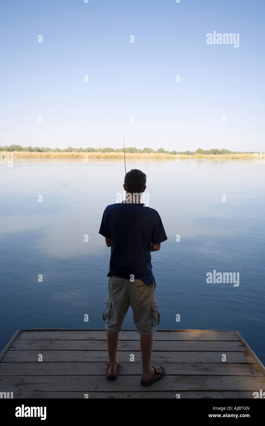 Giovane uomo la pesca in fiume Zambezi - Vista posteriore Foto Stock