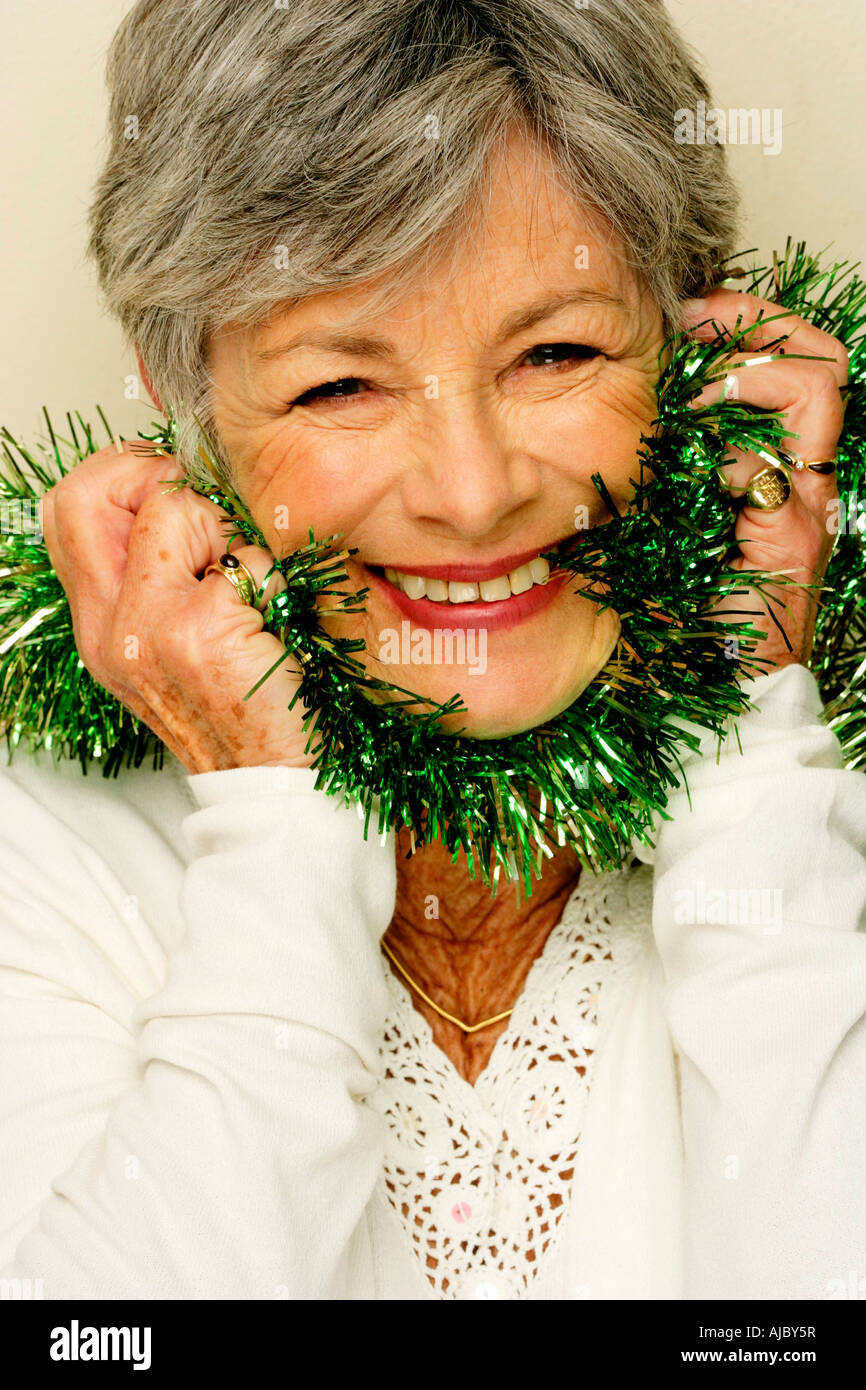 Ritratto di una donna matura indossando Tinsel intorno al collo Foto Stock