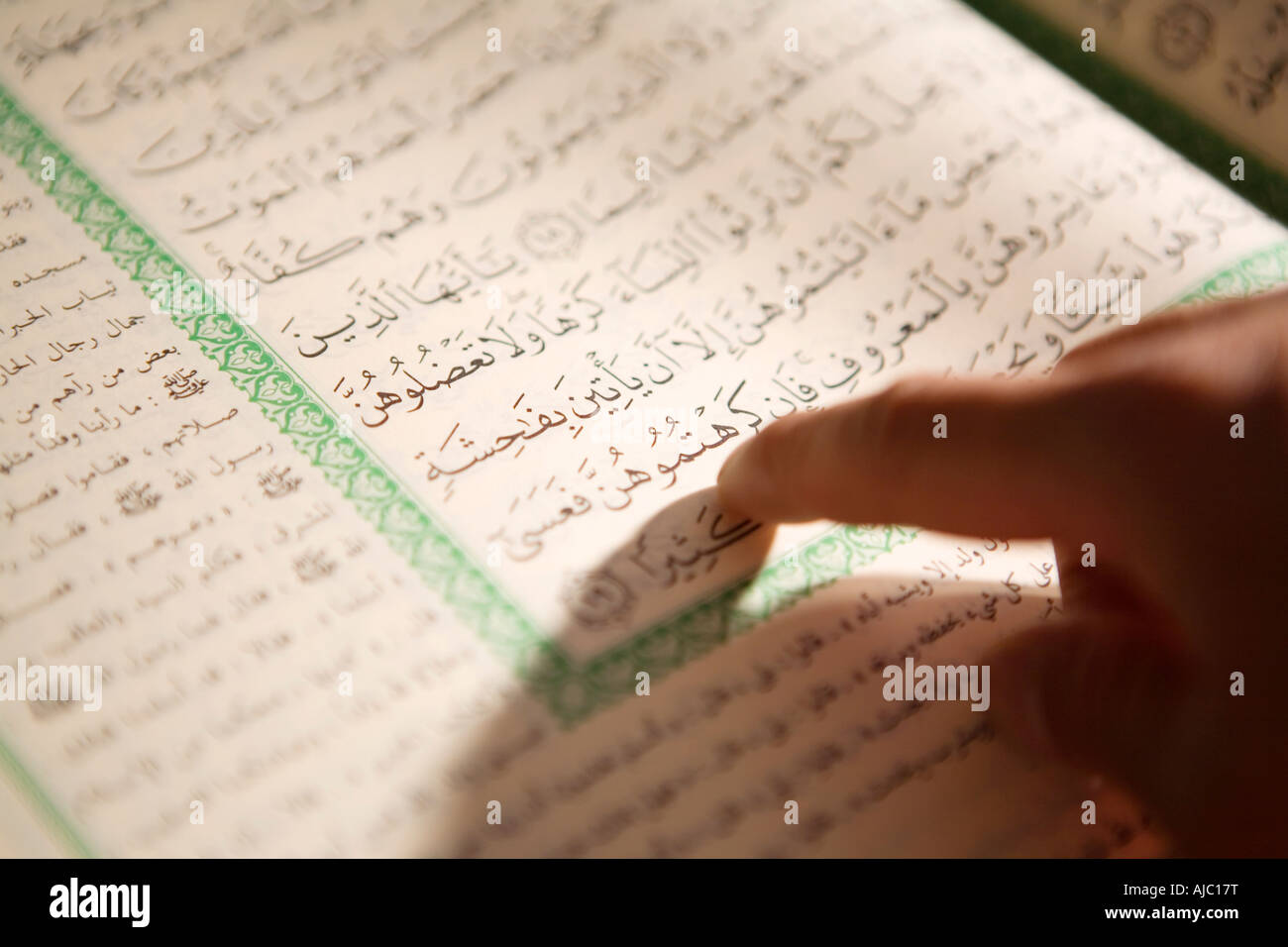 L'uomo la lettura del Corano in calligrafia Araba Foto Stock