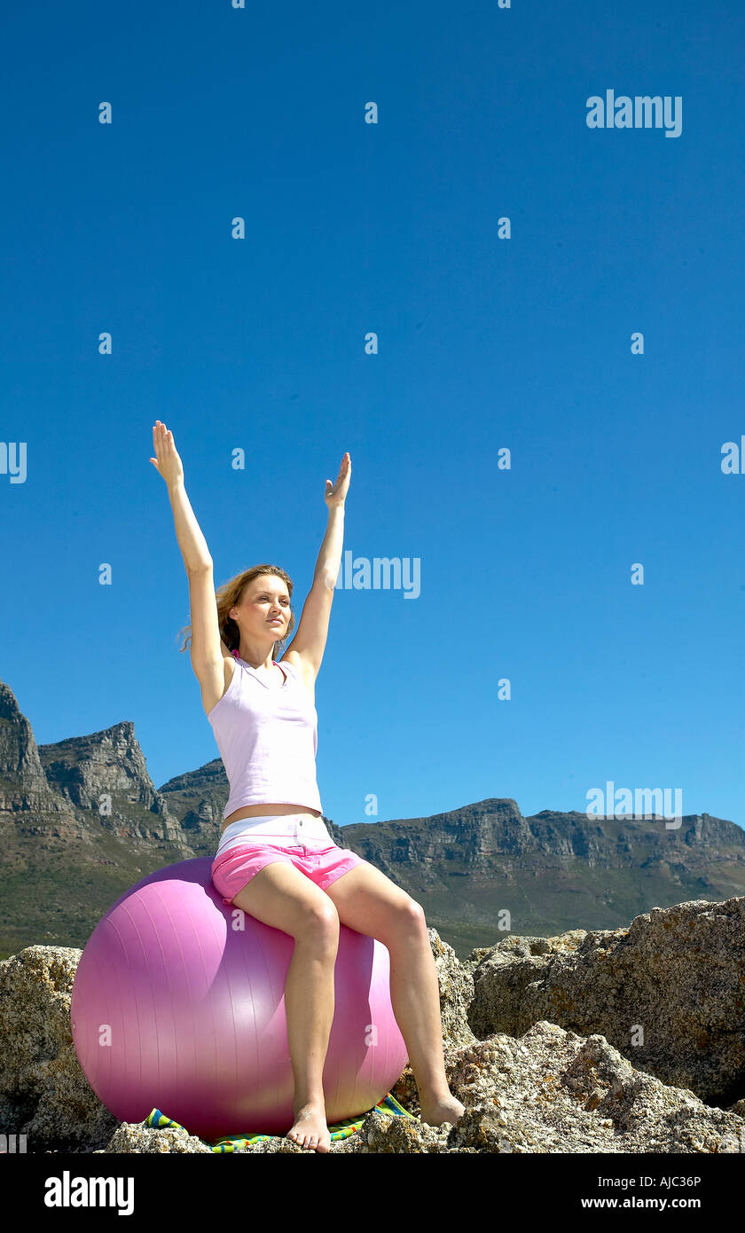 Giovane donna che esercitano su di una sfera di fitness Foto Stock