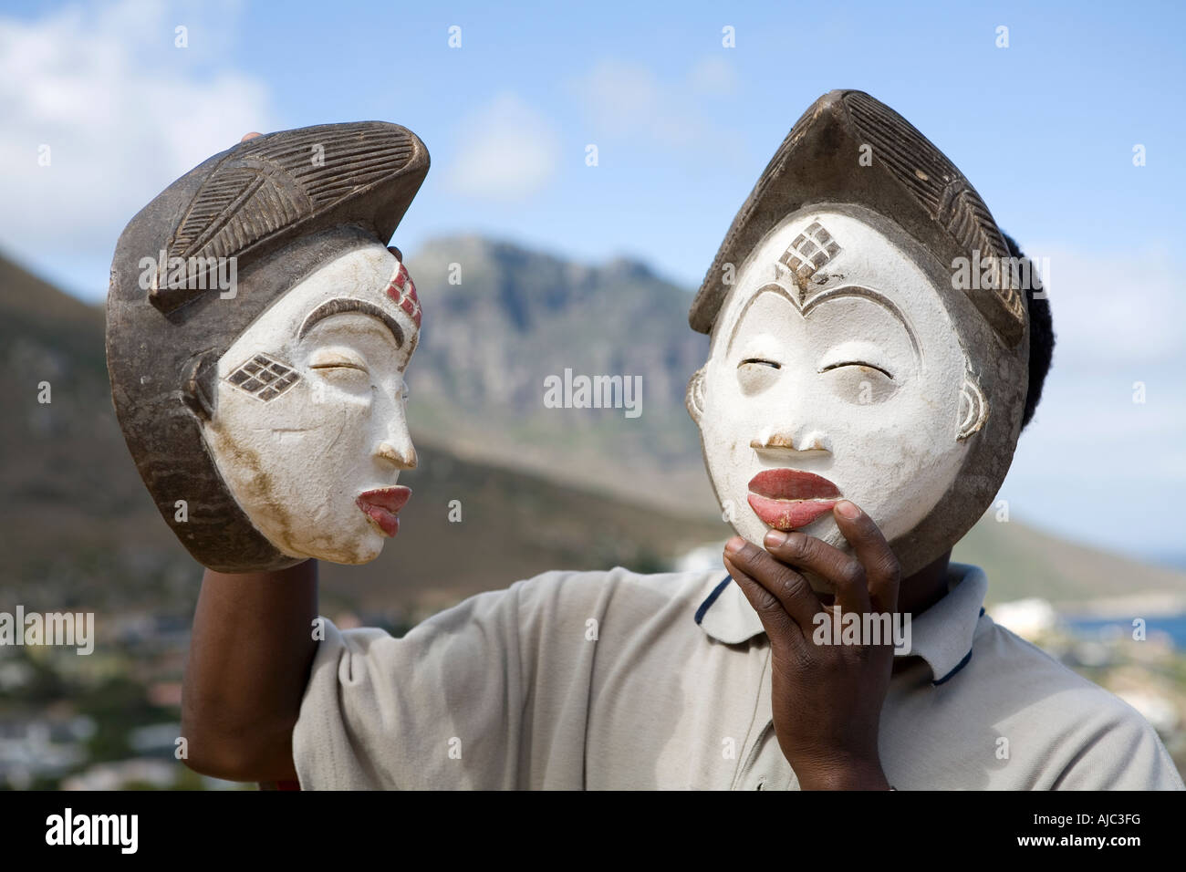 Uomo con una maschera africana sul suo volto, e un altro in mano Foto Stock