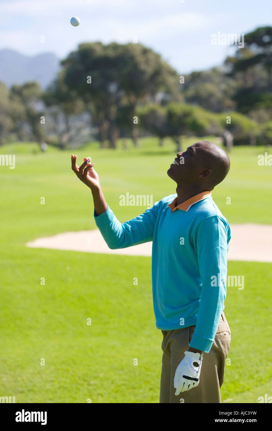 L'uomo gettando pallina da golf in aria Foto Stock