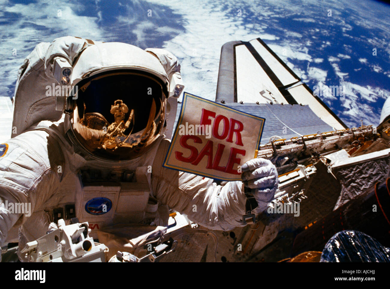 L'astronauta Dale A. Gardner tiene il segno 'per la vendita' come uno scherzo che fa riferimento ai satelliti malfunzionanti che ha aiutato a salvare durante la scoperta dello space shuttle Foto Stock