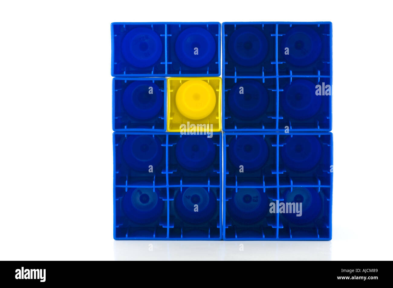 Uno dispari fuori un giallo quadrato in plastica tra i quadrati blu Foto Stock