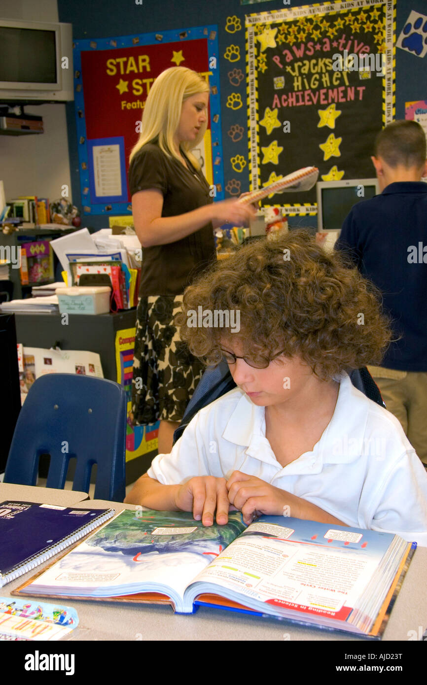 Quarto grado studente la lettura di un libro di testo in una classe in una scuola pubblica in Tampa Florida Foto Stock