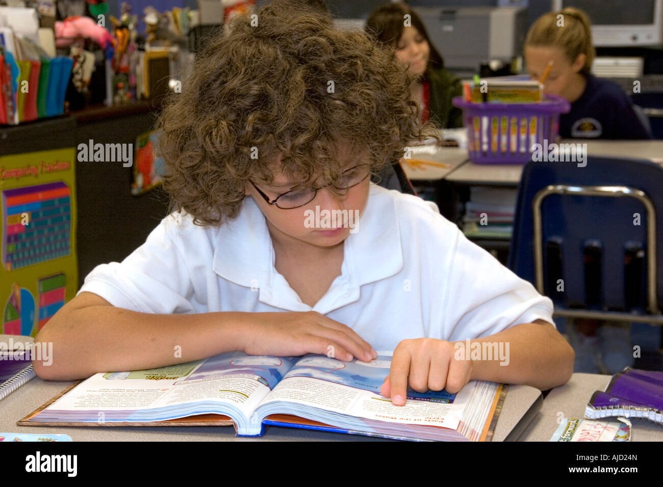 Quarto grado studente legge un libro di testo in una classe in una scuola pubblica in Tampa Florida Foto Stock