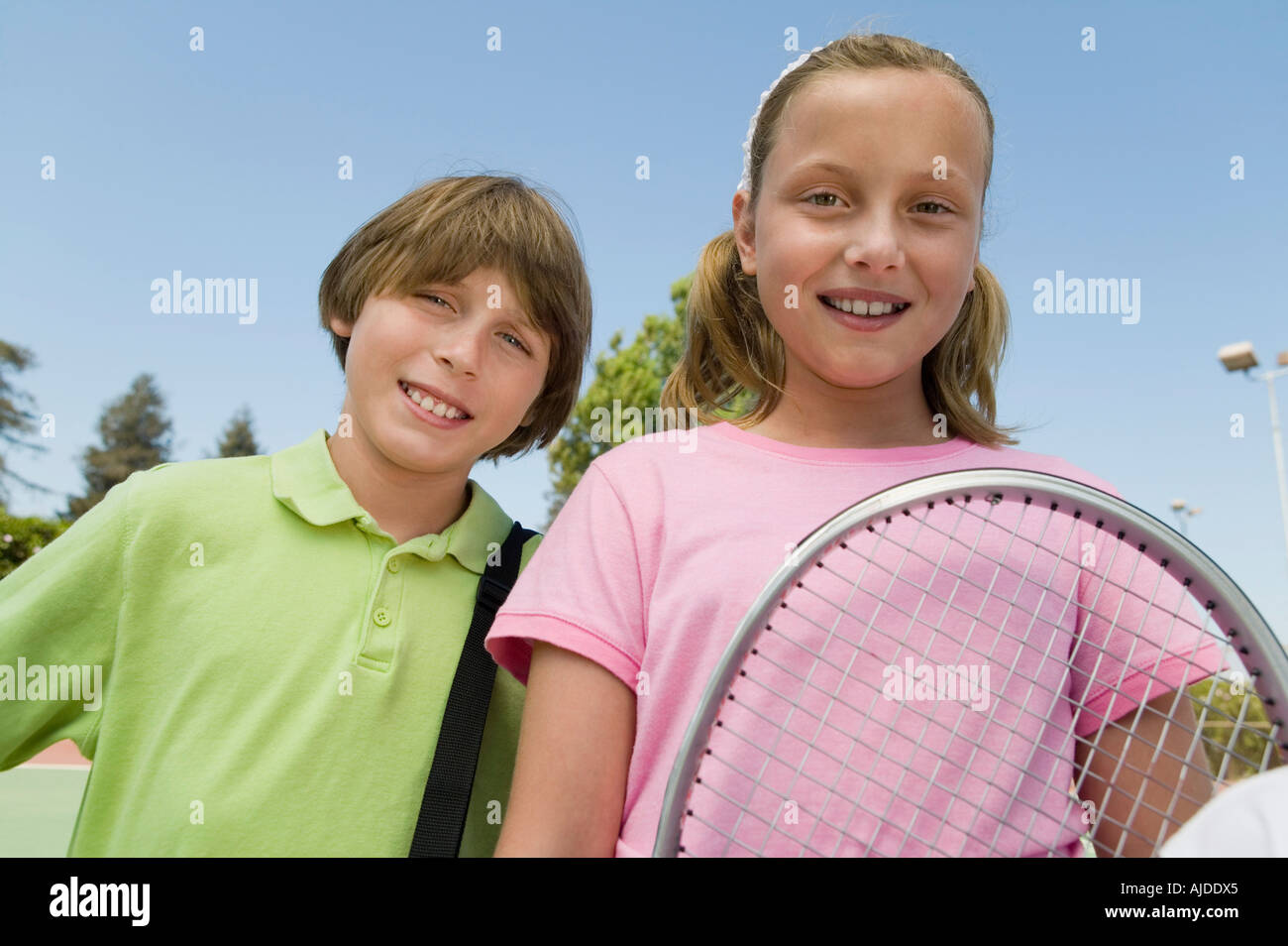 Fratello e Sorella con la racchetta da tennis presso il campo da tennis, ritratto, close up Foto Stock